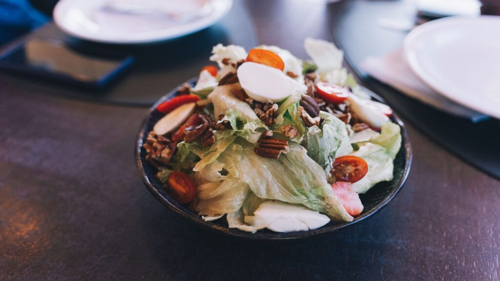 Délicieuse salade fraîche avec des tomates cerises, des noix et de la mozzarella dans un bol.