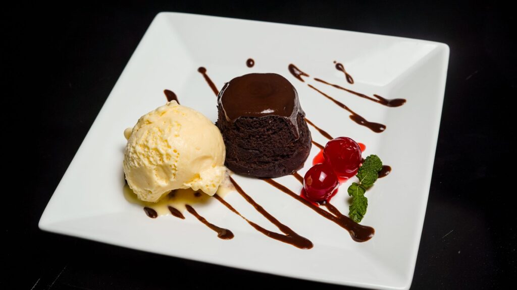 Délicieux gâteau au chocolat servi avec de la glace à la vanille et des cerises.