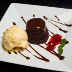Délicieux gâteau au chocolat servi avec de la glace à la vanille et des cerises.