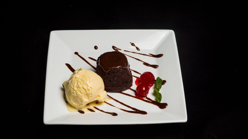 Savourez un riche gâteau au chocolat coulant accompagné de glace et de cerises.