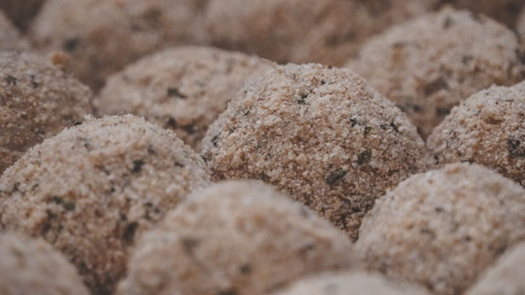 Vue rapprochée de chapeaux de champignons panés assaisonnés prêts à être cuits.