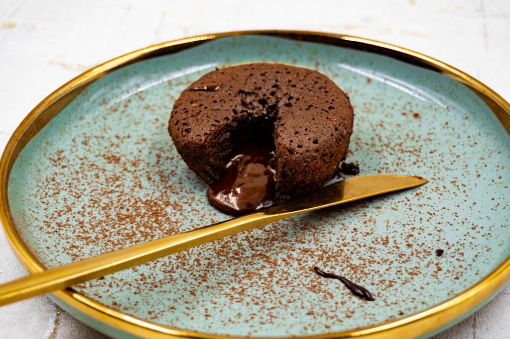 Offrez-vous un riche gâteau au chocolat fondant au centre, servi sur une assiette élégante.