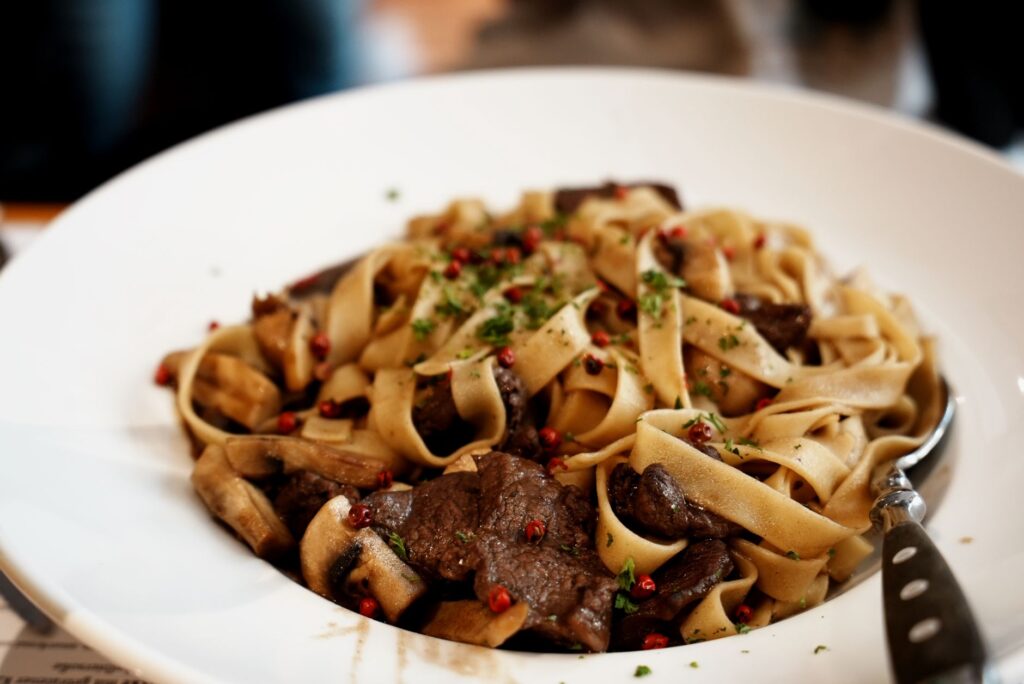 Un plat savoureux de tagliatelle de boeuf garni d'herbes fraîches et d'épices.