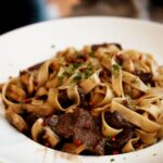 Un plat savoureux de tagliatelle de boeuf garni d'herbes fraîches et d'épices.