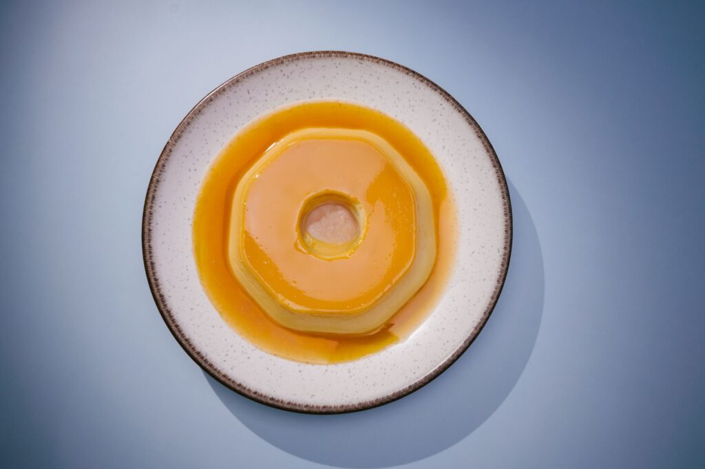 Un délicieux flan brésilien sur une assiette blanche, parfait pour la photographie culinaire et les sites gastronomiques.