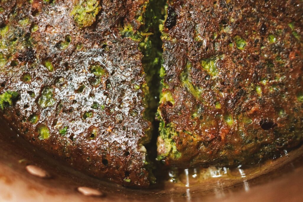 Gros plan sur un délicieux beignet de légumes verts croustillant à la surface texturée, parfait pour les gourmands.