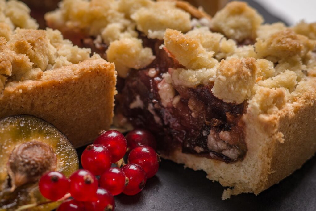Gros plan sur une appétissante tarte aux baies avec des fruits frais sur une surface sombre.