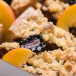 Délicieux crumble aux pêches et aux mûres, recouvert d'un crumble doré. Parfait pour le dessert ou le goûter.