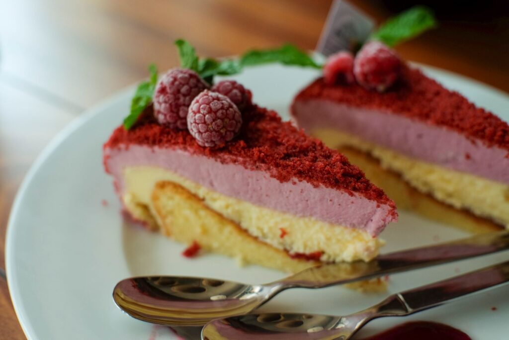 Gros plan sur une part de cheesecake aux framboises garnie de menthe, parfaite pour les amateurs de desserts.