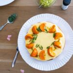 Délicieux gâteau à l'orange et au romarin présenté sur une table en bois ornée de fleurs.
