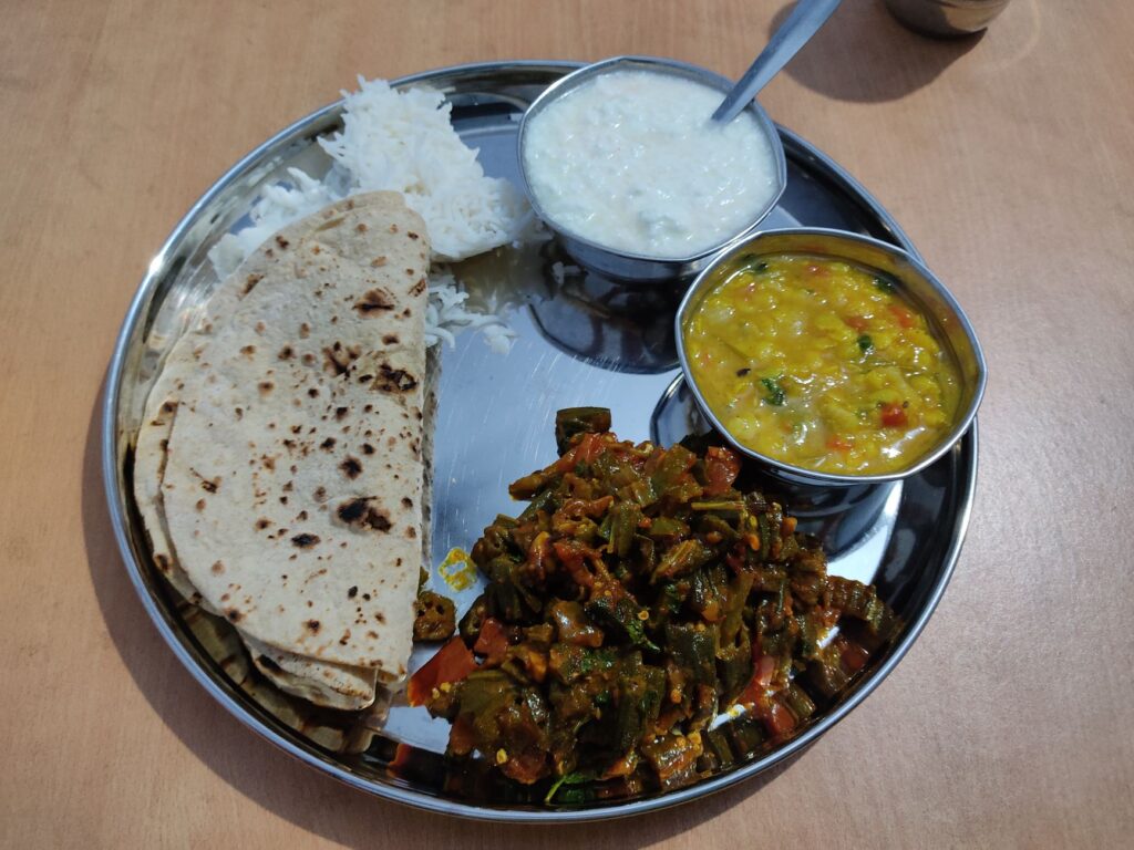 Un délicieux thali indien composé de chapati, de riz, de dal, de gombo et de yaourt. Un repas végétarien traditionnel.