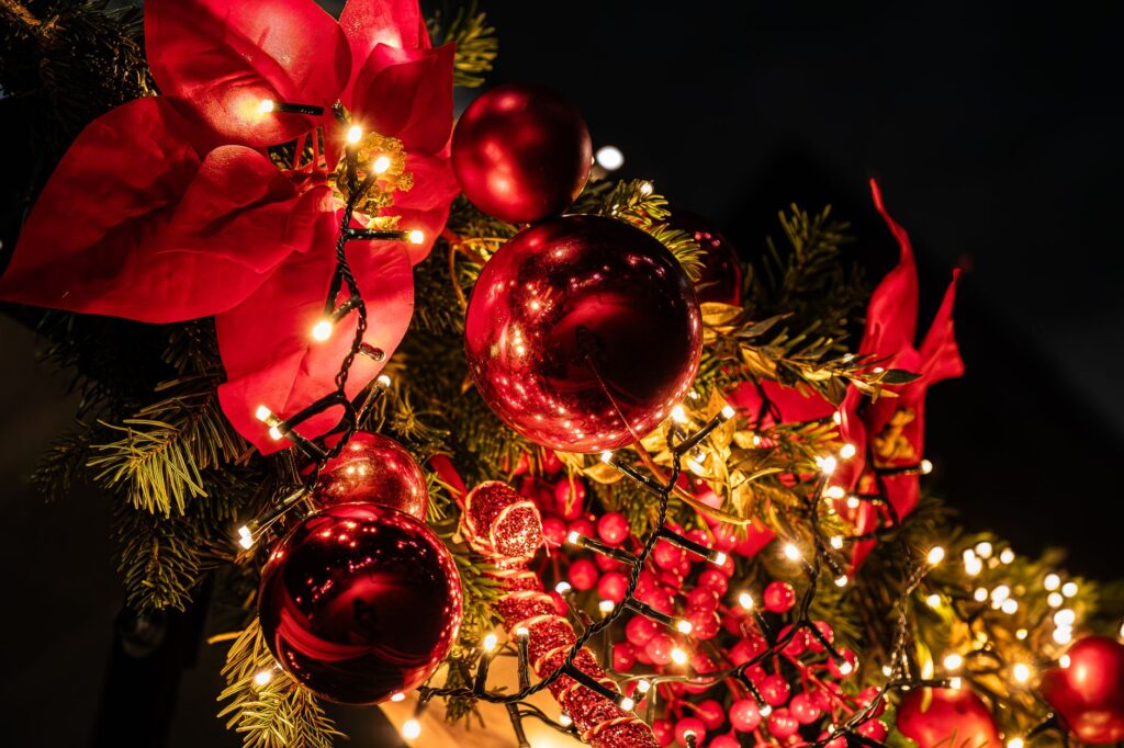 Guirlande de Noël scintillante avec lumières et boules à Paris, capturant l'esprit des fêtes.