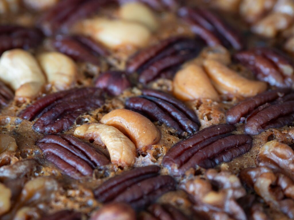 Un délicieux gâteau aux fruits maison, garni d'un riche assortiment de noix, parfait pour les occasions festives.