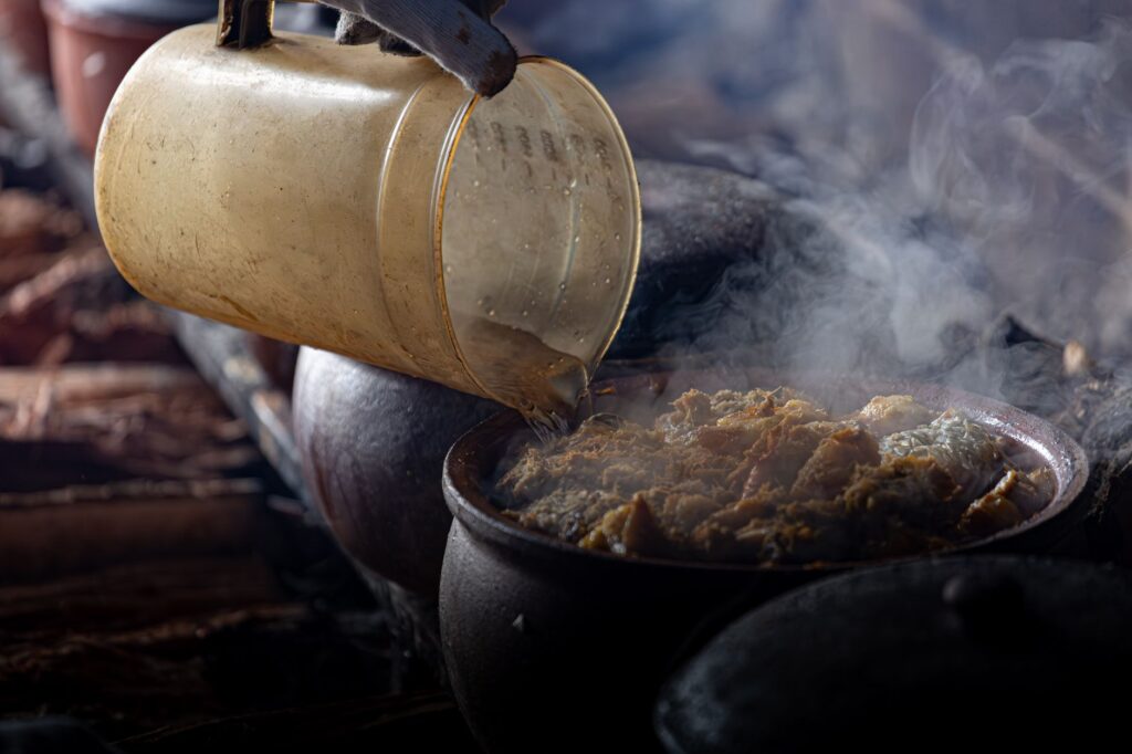 Une marmite en terre cuite fumante dans une cuisine vietnamienne, selon des méthodes de cuisson traditionnelles.