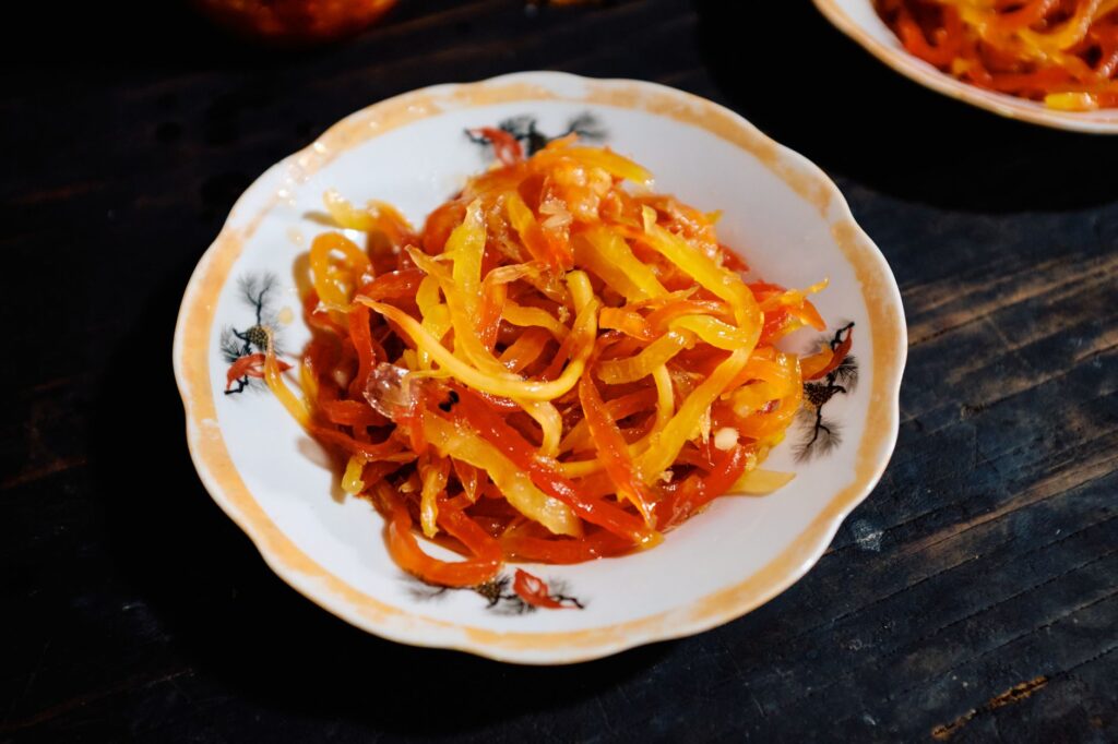 Papaye marinée colorée servie pour le Têt au Vietnam, illustrant la cuisine festive traditionnelle.