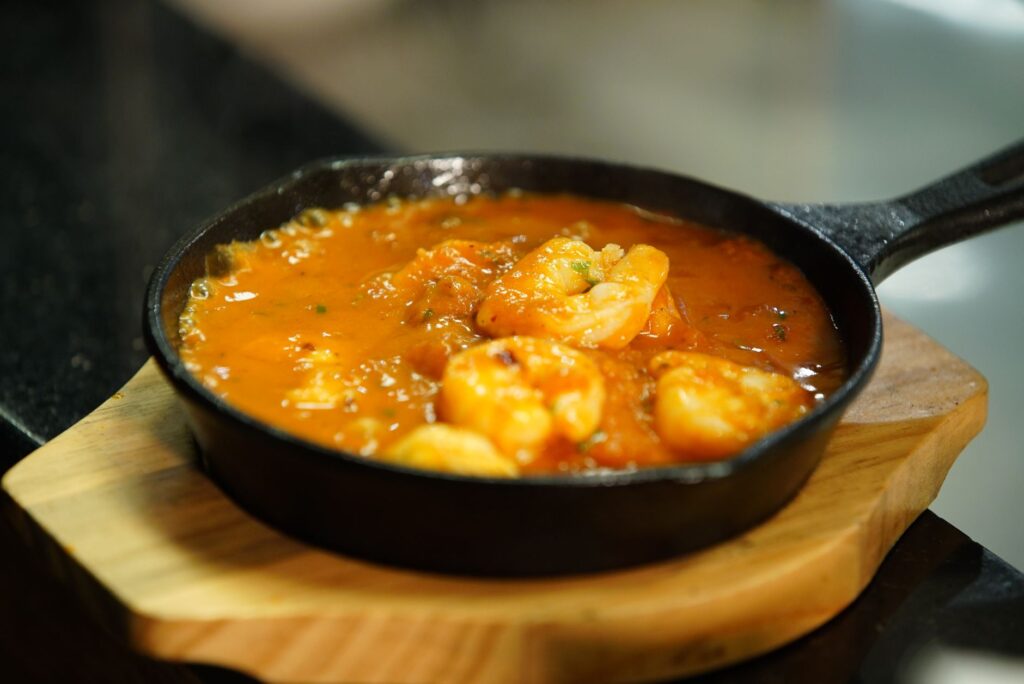 Délicieuses crevettes mijotant dans une riche sauce tomate dans une poêle en fonte.