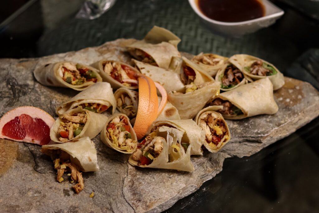 Savourez des wraps gourmands préparés avec des ingrédients frais et servis sur une ardoise rustique. Idéal pour les fins gourmets.