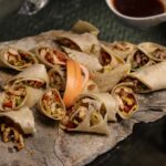Savourez des wraps gourmands préparés avec des ingrédients frais et servis sur une ardoise rustique. Idéal pour les fins gourmets.