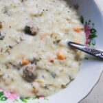 Délicieuse soupe crémeuse aux boulettes de viande, servie dans un bol à motifs floraux avec une cuillère.