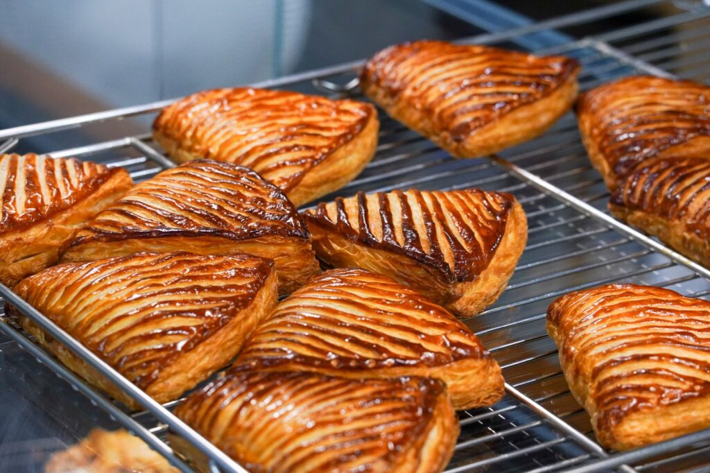 Chaud et doré, ces chaussons aux pommes refroidissent sur une grille, parfaits pour les amateurs de desserts.