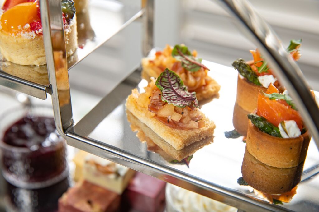 Un gros plan d'un plateau de thé de l'après-midi élégant présentant une sélection de mets délicats et de desserts.