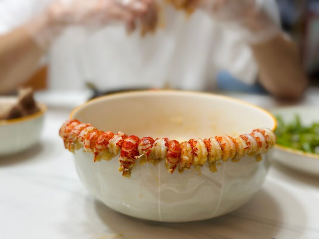 Gros plan sur des queues de homard élégamment disposées sur le bord d'un bol, évoquant un repas gastronomique.