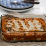 Savoureuse lasagne cuite dans un plateau en verre sur une nappe en jute, prête à être servie.
