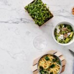 Vue de dessus d'un repas nutritif avec salade et pâtes sur une surface en marbre, parfait pour des thèmes de alimentation saine.