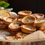Un gros plan de mini quiches fraîchement cuites, parfaites pour des amuse-bouches de fête.