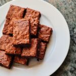 Une vue de dessus de délicieux brownies au chocolat fraîchement cuits, servis sur une assiette en céramique blanche.