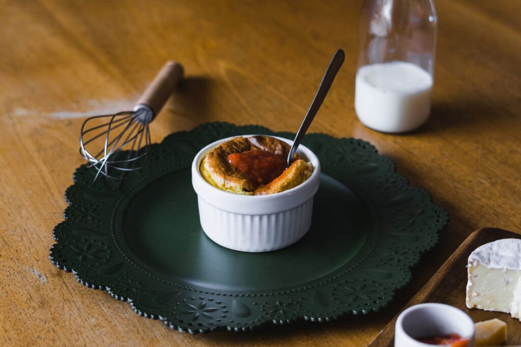 Un soufflé appétissant servi sur une assiette rustique avec du lait et du fromage sur une table en bois.