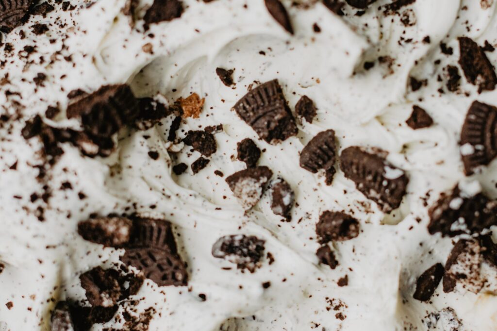 Gros plan de glace crémeuse surmontée de miettes de biscuits au chocolat, un délice sucré.