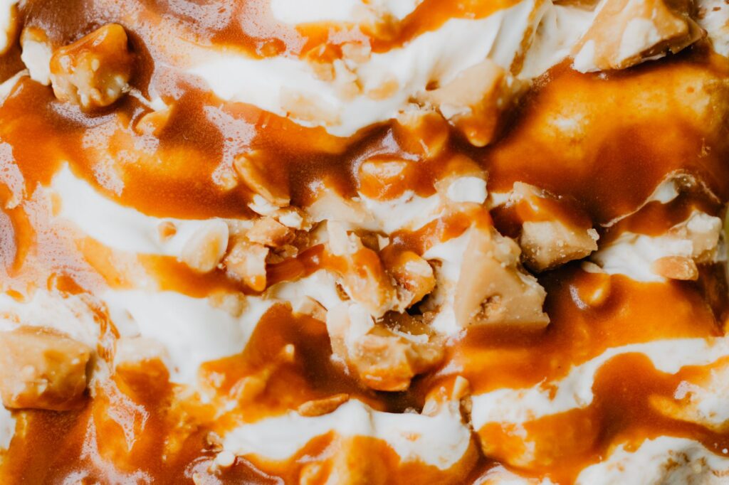 Riche glace vanille garnie de sauce caramel et de noix croquantes.