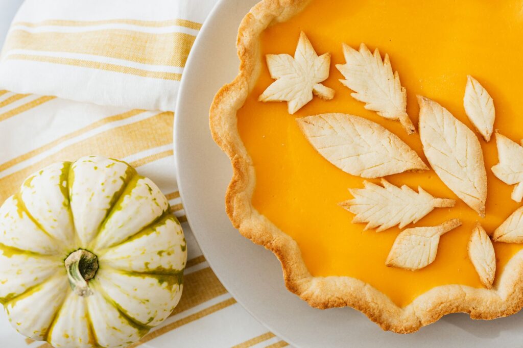 Délicieuse tarte au potiron avec décoration de croûte en feuilles, parfaite pour les célébrations d'automne.