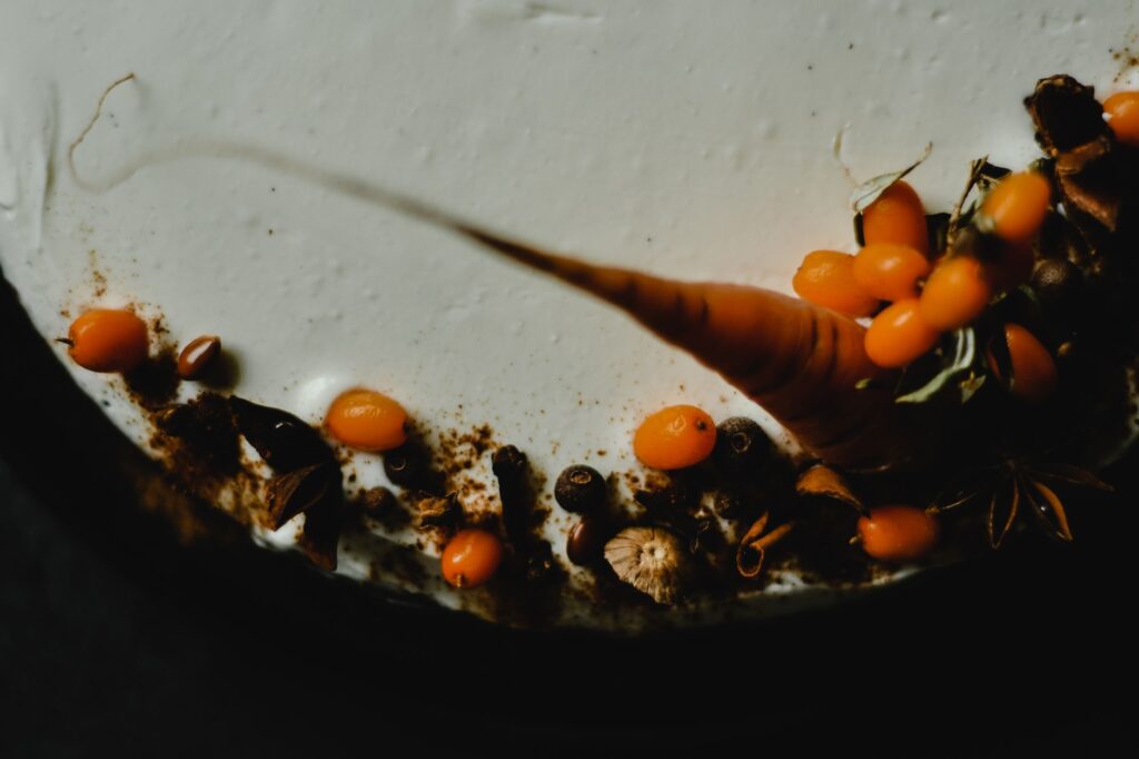 Gros plan sur un gâteau aux carottes avec des garnitures élaborées telles que des baies orange et des épices.