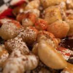 De savoureuses boules de pâte frite saupoudrées de sucre et nappées de sauces.