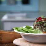Délicieuse et saine salade de quinoa garnie de grenade, de menthe et d'une vinaigrette crémeuse sur un lit de laitue fraîche.
