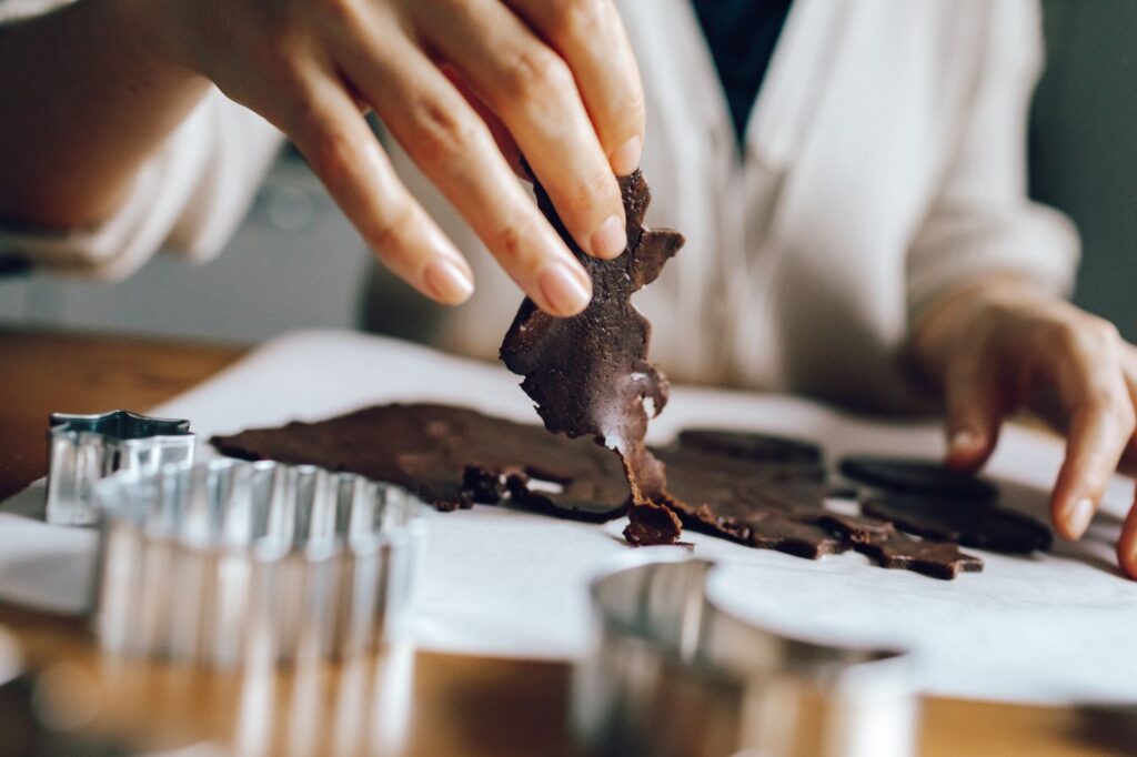 Une vue détaillée d'une personne faisant des cookies au chocolat maison. Scène de pâtisserie intérieure.