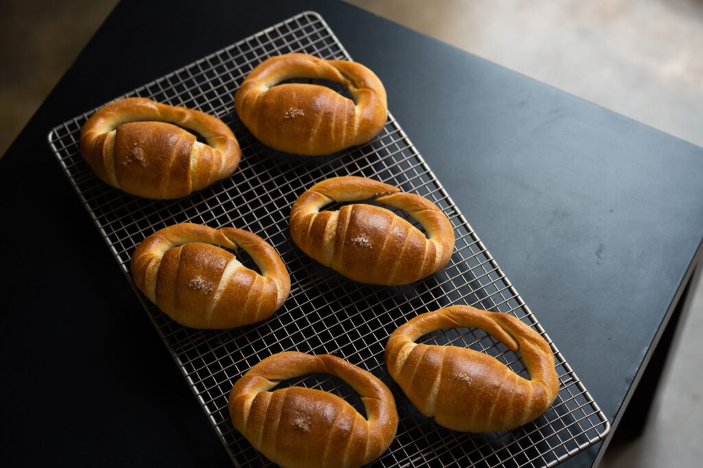 Des petits pains fraîchement cuits disposés sur une grille de refroidissement, capturés de haut.
