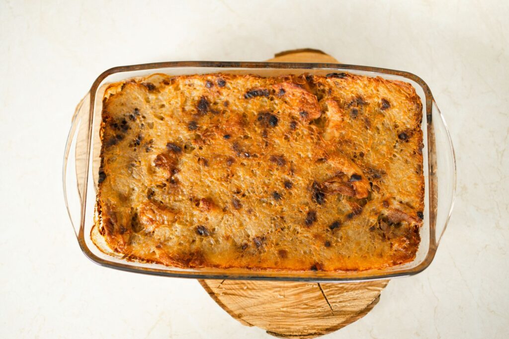 Vue de dessus d'un plat de casserole fraîchement cuit dans un plat en verre sur une planche en bois.