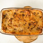 Vue de dessus d'un plat de casserole fraîchement cuit dans un plat en verre sur une planche en bois.