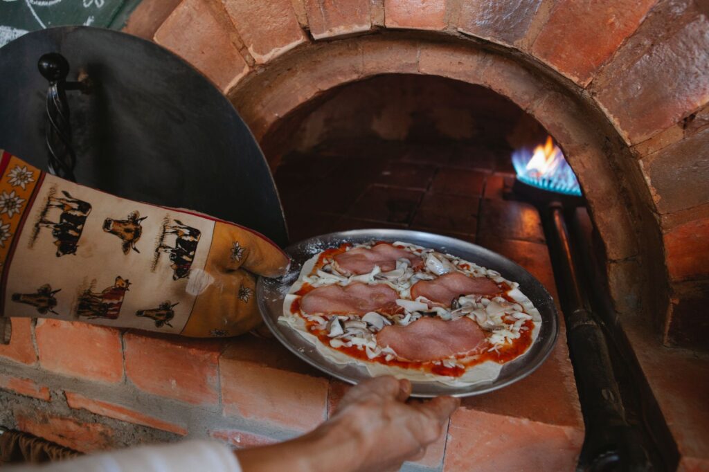 Une délicieuse pizza au jambon et au fromage cuite dans un four traditionnel à bois.