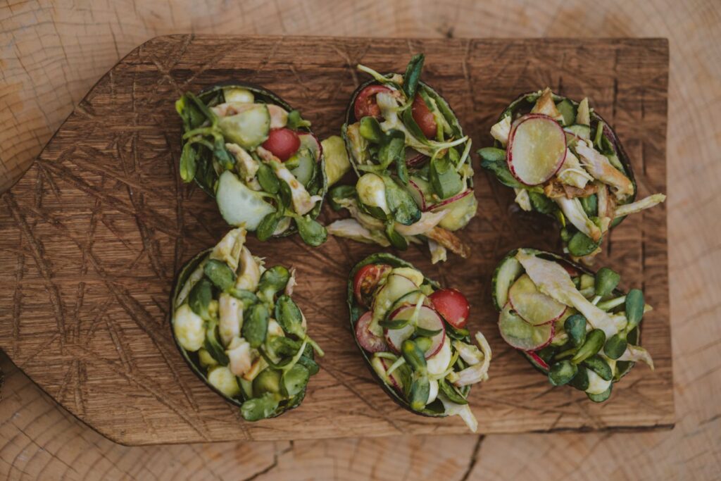 Tasses de salade saines avec des légumes frais disposés sur une planche en bois rustique.