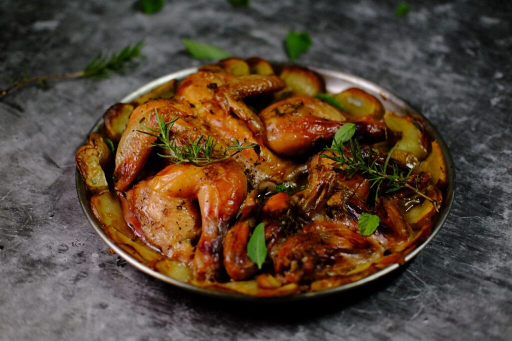 Une assiette de poulet rôti appétissante garnie d'herbes fraîches et de pommes de terre.