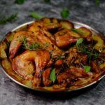 Une assiette de poulet rôti appétissante garnie d'herbes fraîches et de pommes de terre.