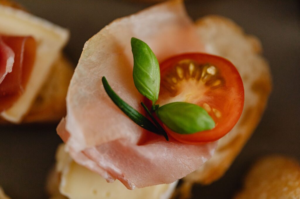 Délicieuse bruschetta garnie de prosciutto, basilic et tomate.