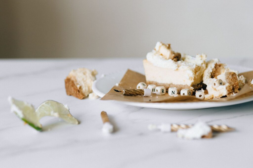 Gros plan d'un gâteau tranché avec des perles alphabétiques éparpillées sur une table.