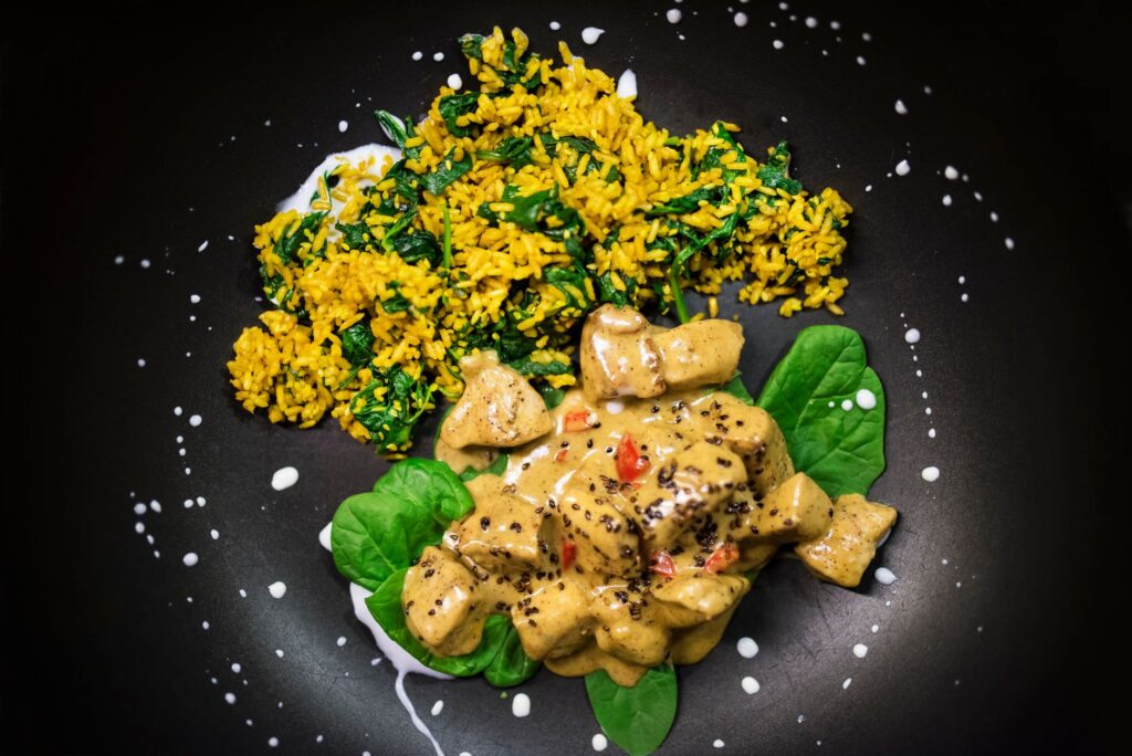 Délicieux curry de poulet avec sauce crémeuse et riz infusé aux épinards.