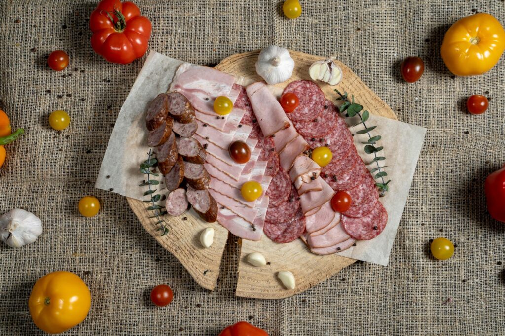 Un assortiment savoureux de viandes et de légumes présenté sur une planche rustique.