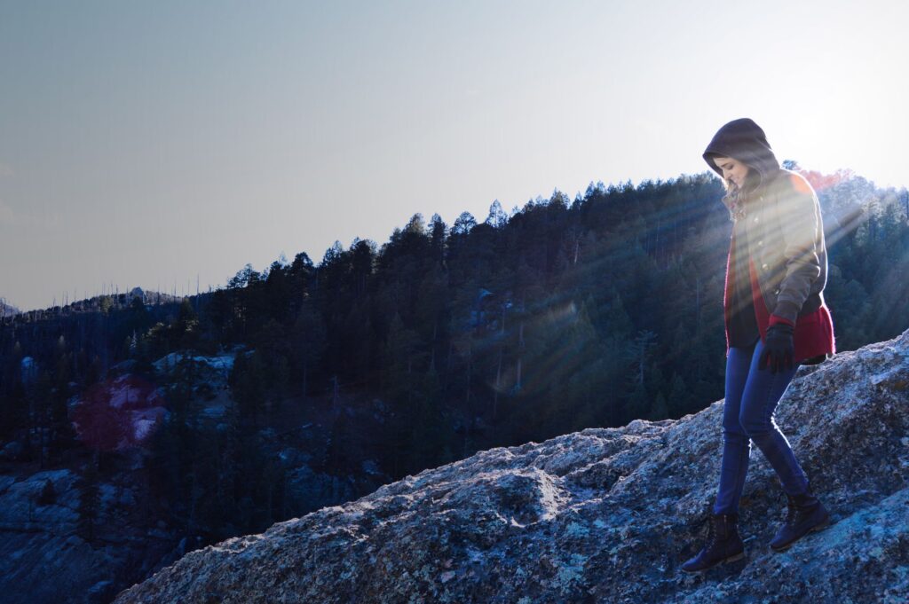 Personne faisant de la randonnée sur un terrain rocailleux au Mont Lemmon au lever du soleil avec une vue pittoresque sur la forêt.